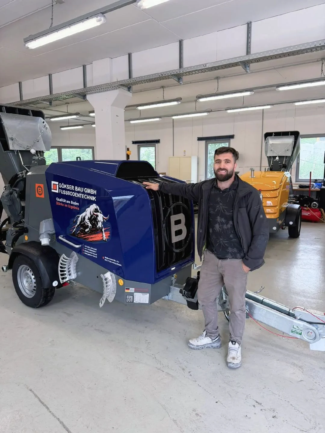 Betriebsbereite elektrische Estrichmaschine mit Mitarbeiter